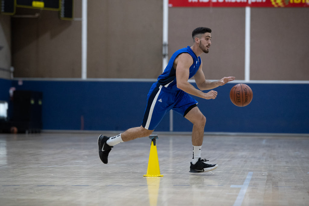 A basketballer dribbling around the court