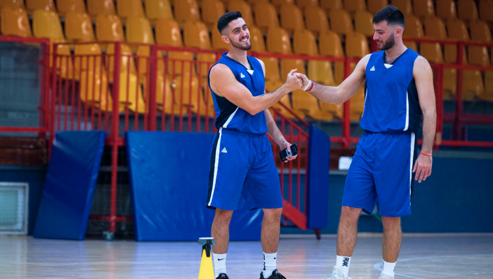 Two basketball players having a break and sharing a laugh