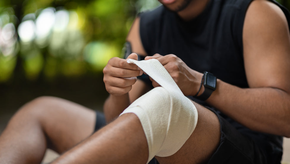 An athlete wrapping his leg in a bandage