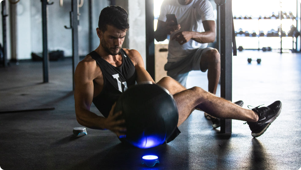 An athlete using a medicine ball to do a Russian Twist drill