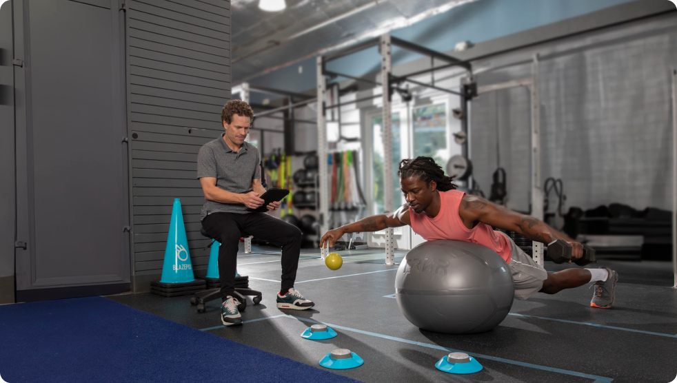 A physical therapist helping his patient improve his physical and mental form with BlazePod