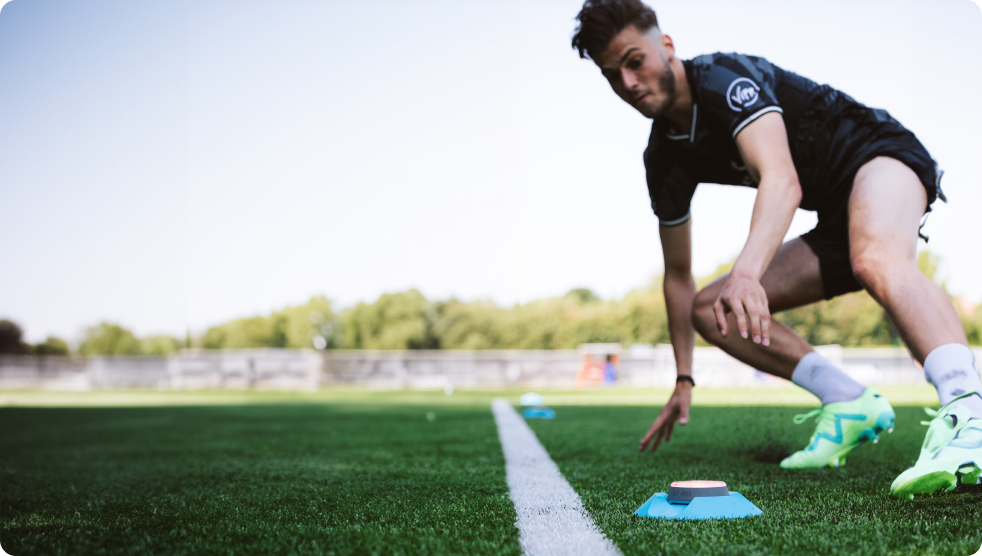 An athlete on a soccer pitch tapping a Pod light