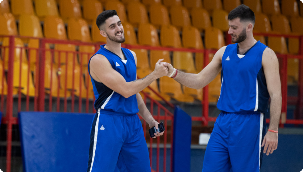 Two basketball teammates celebrating and highfiving each other